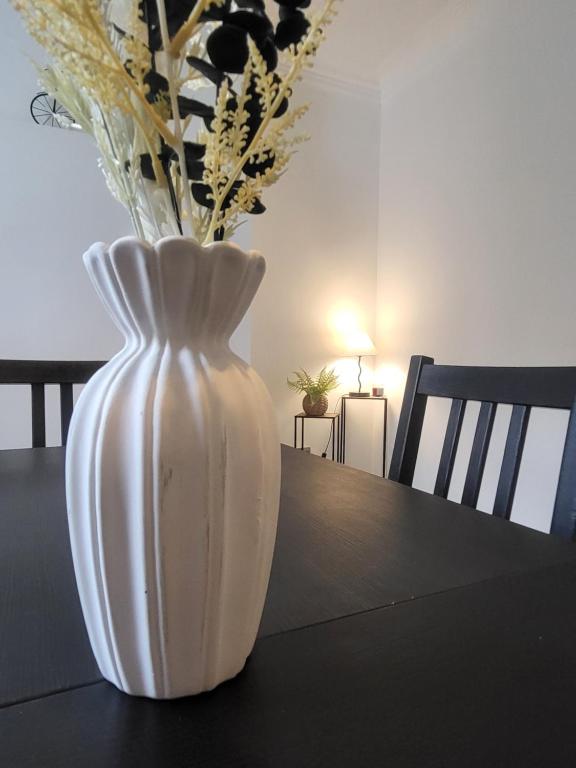a white vase sitting on a table with flowers at Relaxing Seaside Stay 3-Bed Home Minutes from Hythe Beach in Hythe