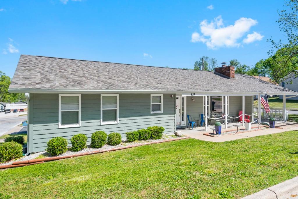 a green house with a flag in front of it at Branson Downtown Beauty - 4 BDR Home Sleeps 15 in Branson