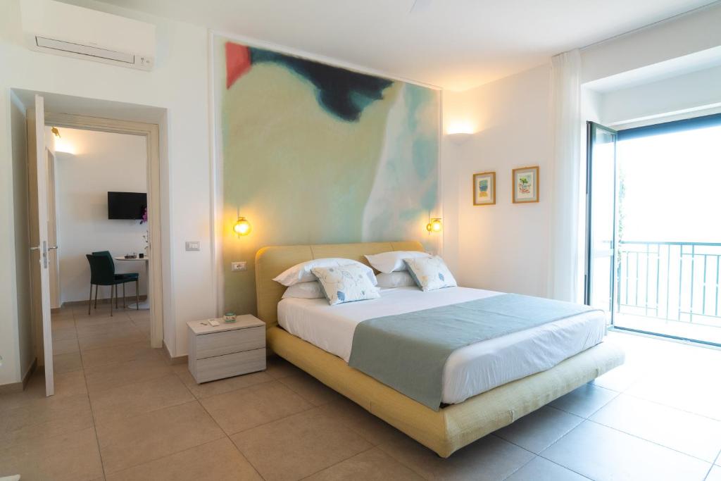 a bedroom with a bed with a painting on the wall at Mare Luna - Enchanting sea view apartment in Ravello