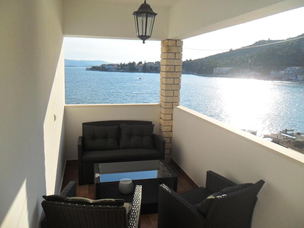 einen Balkon mit Sofa und Blick auf das Wasser in der Unterkunft Apartment Ante in Klek