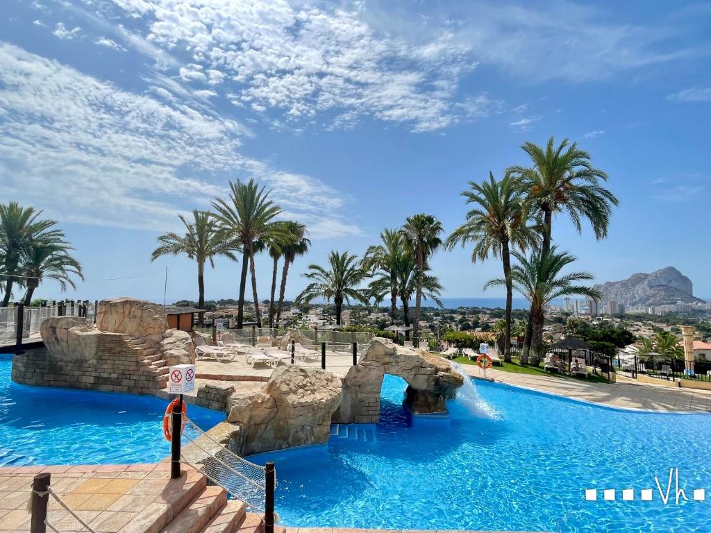 a pool at a resort with palm trees at VH Costa Blanca - APARTAMENTO ABANTOS in Casas de Torrat