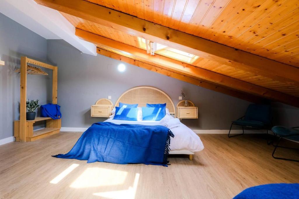 a bedroom with a large bed with blue pillows at Ático Alfonso Amplio Céntrico Renovado 10 Pax in Zaragoza