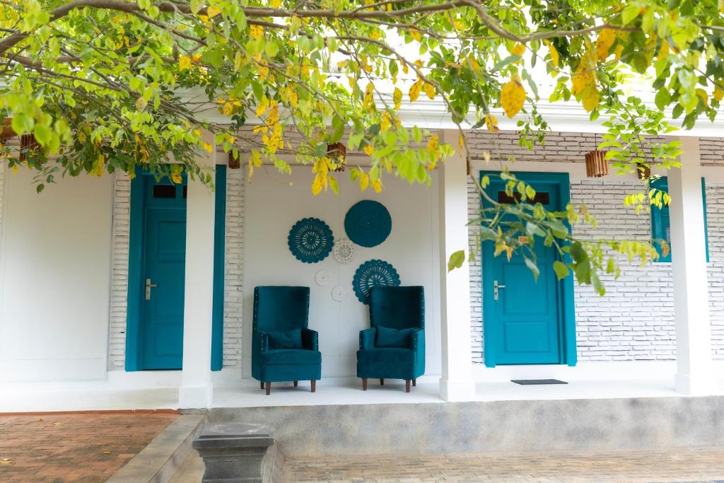 two chairs on a porch with blue doors at Chitta in Nikawatawana