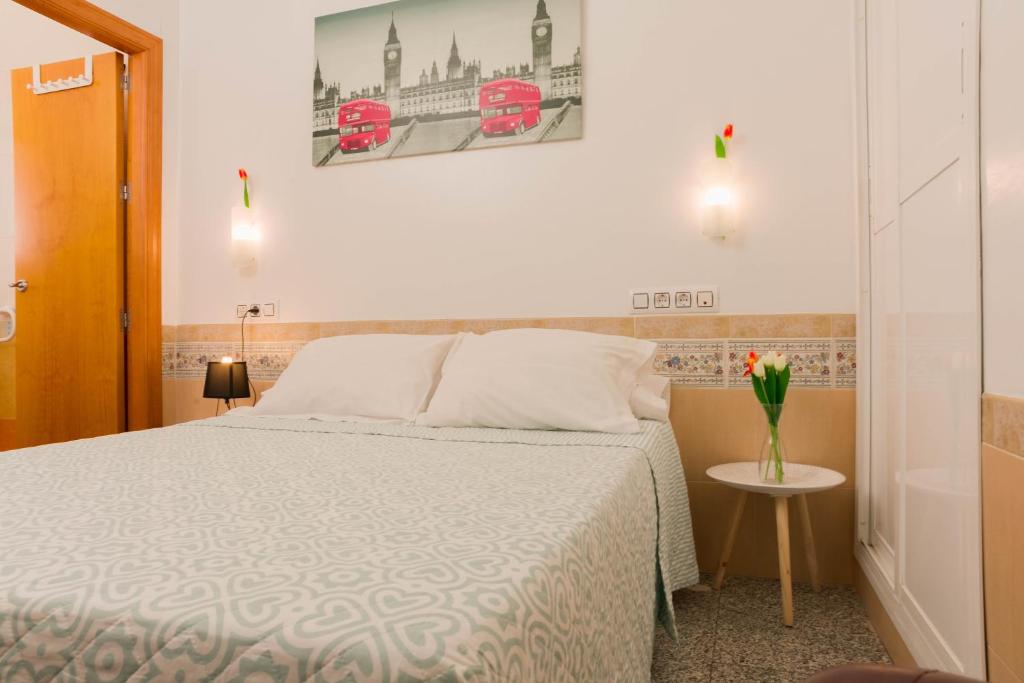 sypialnia z łóżkiem i wazonem z kwiatami na stole w obiekcie Aire Hostal en Los Alcores w mieście El Viso del Alcor