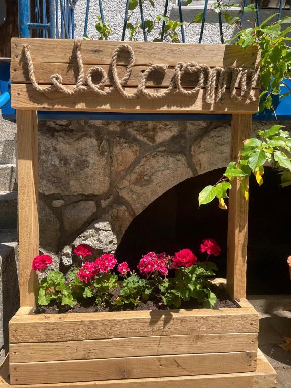 a wooden flower box with red flowers in it at At the Burkulis' in Ljubljana