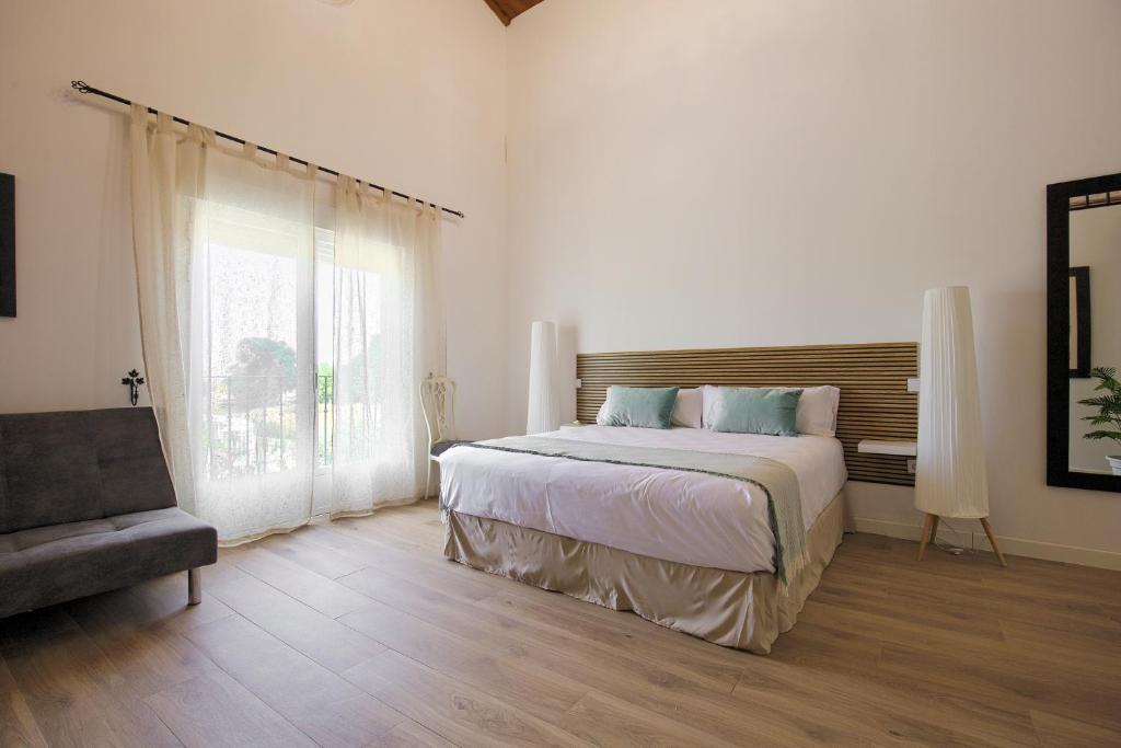 a bedroom with a bed and a chair and a window at Hotel Finca Biazu in Ocaña
