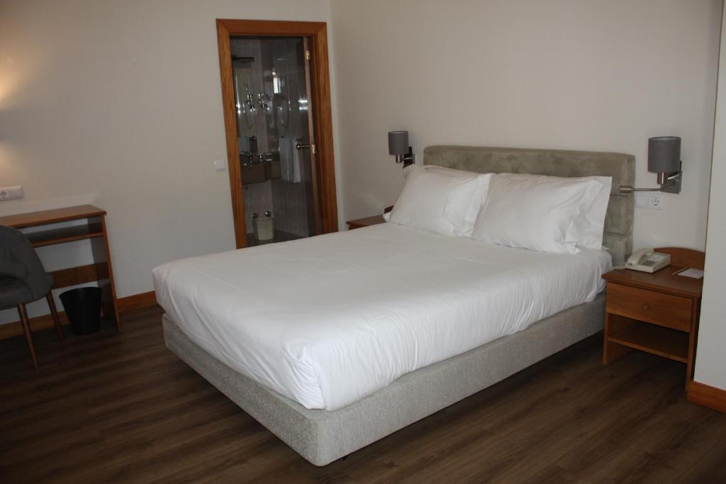 Postel nebo postele na pokoji v ubytování Hotel Toural