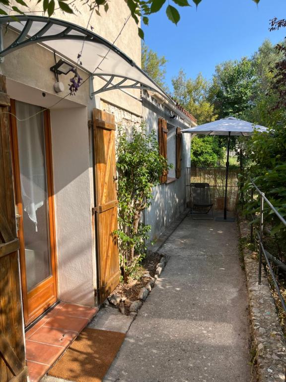 un passaggio esterno di una casa con un ombrellone di La Cigalière - Appartement Rez-de-Jardin a Vallauris