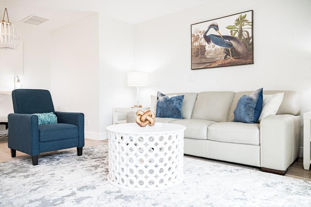 a living room with a white couch and a blue chair at Modern Coastal Home in Clearwater Beach