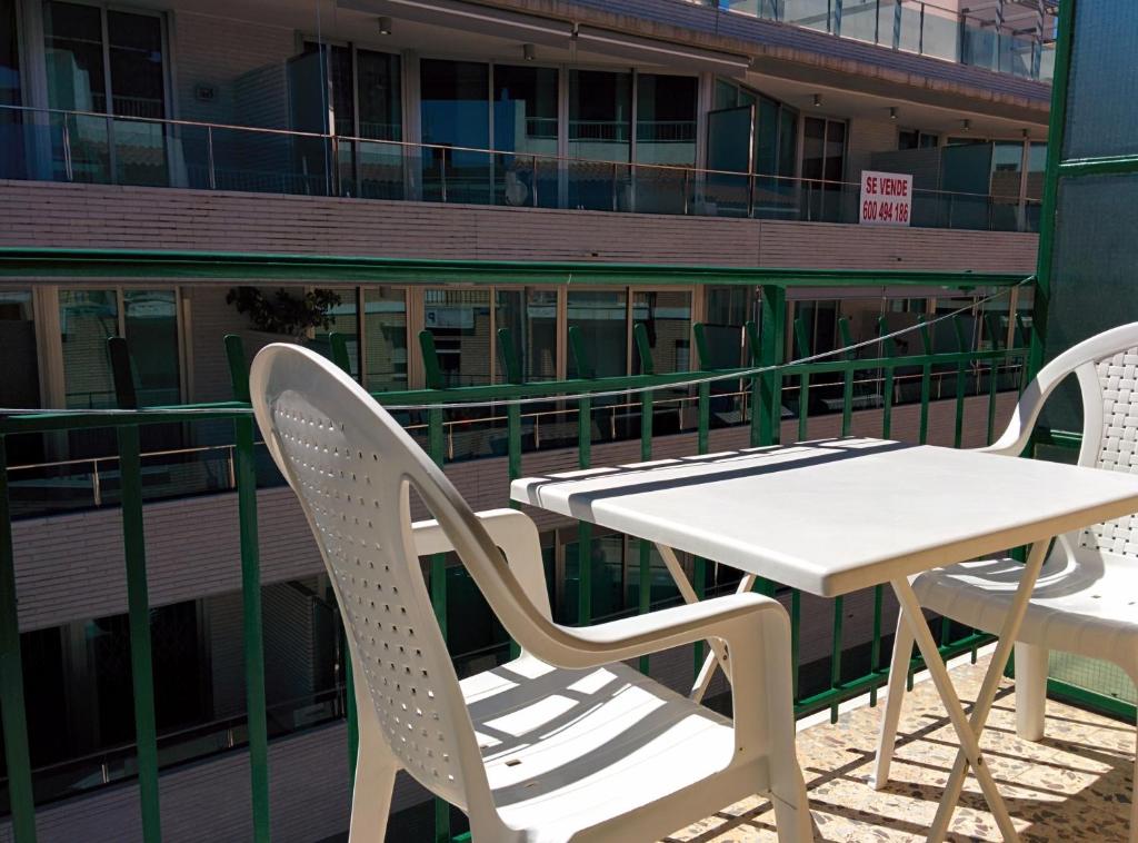 a table and chairs on a balcony with a building at PENSIÓN EGEA 1 in Puerto de Mazarrón
