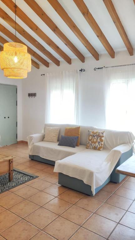 a living room with two couches and a chandelier at Casa Verde Oliva in Sedella