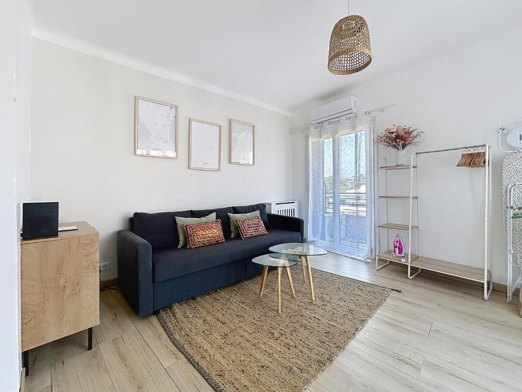 un salon avec un canapé bleu et une table dans l'établissement Studio Hippodrome, à Cagnes-sur-Mer