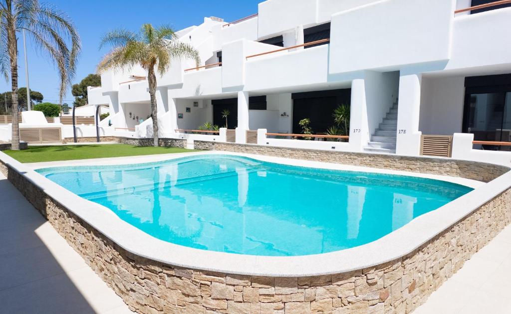 a swimming pool in front of a villa at Cactus Apartment La Ribera in Santiago de la Ribera