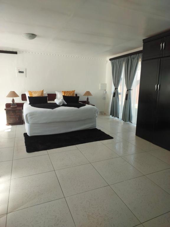 a bedroom with a white bed in a room at NEW LODGE - Universitas in Bloemfontein