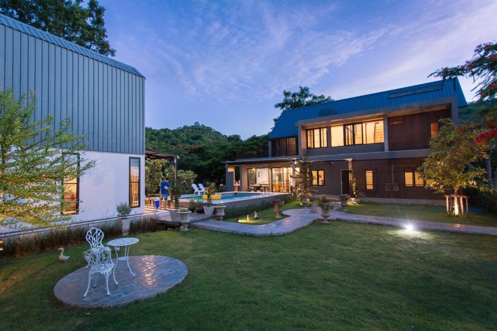 a large house with a yard in front of it at Cosy Pool Villa Khaoyai in Nong Nam Daeng