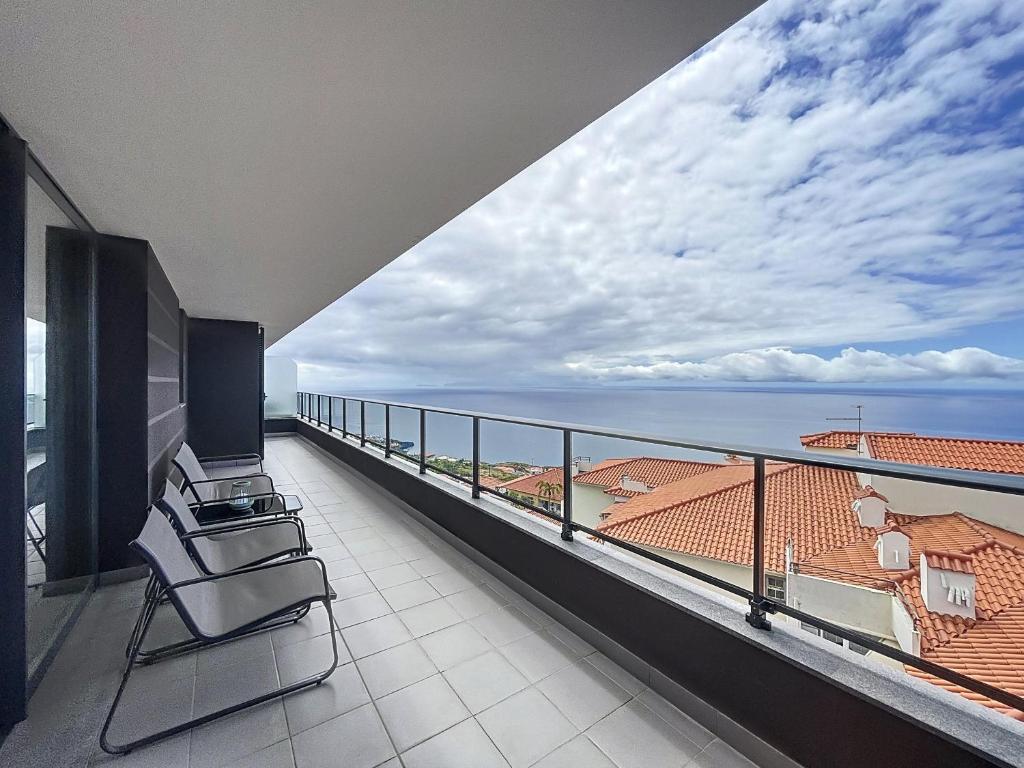 a balcony with two chairs and a view of the ocean at Atlantic Haven by Atlantic Holiday in Garajau