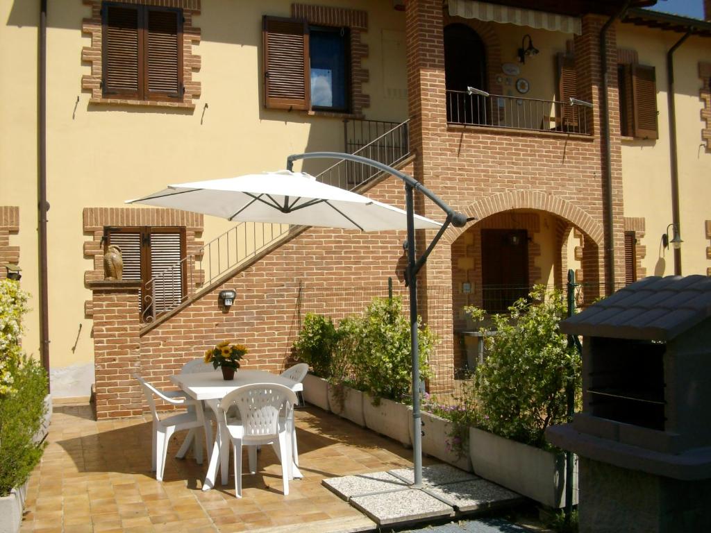 a table with an umbrella in front of a building at La Loggina in Tuoro sul Trasimeno