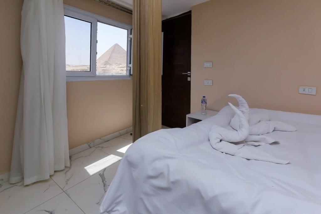 Postel nebo postele na pokoji v ubytování Rizkyan pyramids view INN