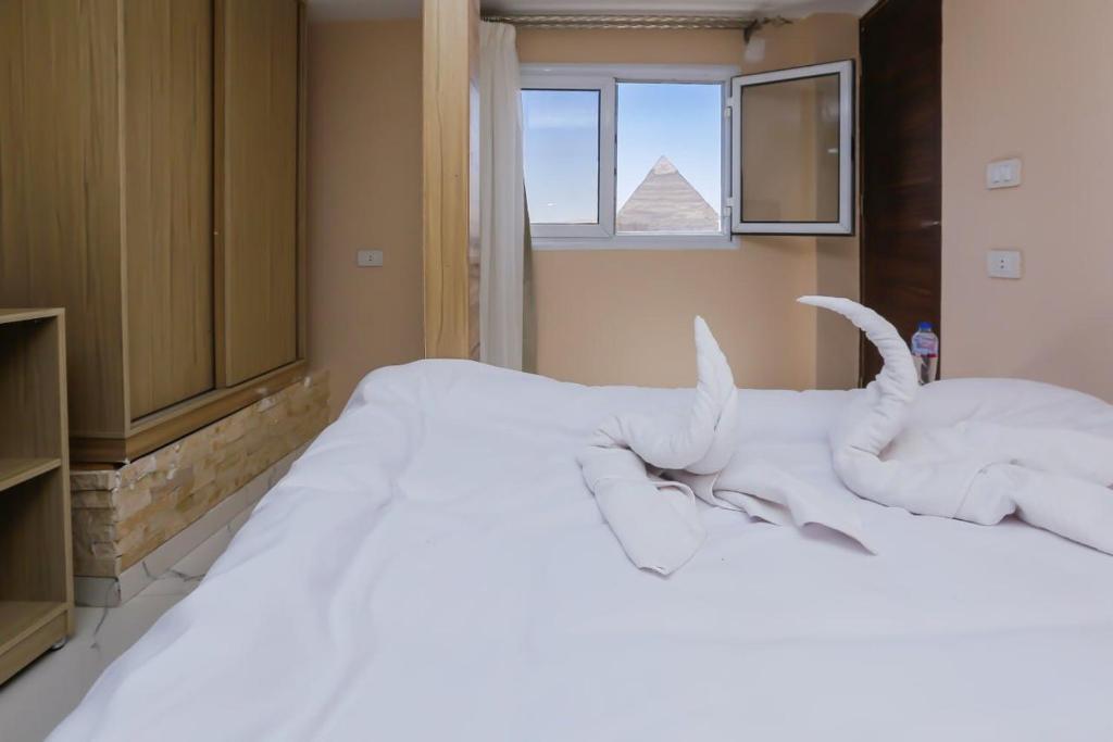 Postel nebo postele na pokoji v ubytování Rizkyan pyramids view INN
