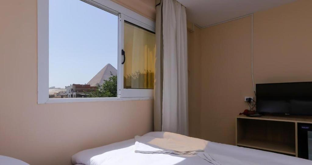 Postel nebo postele na pokoji v ubytování Rizkyan pyramids view INN
