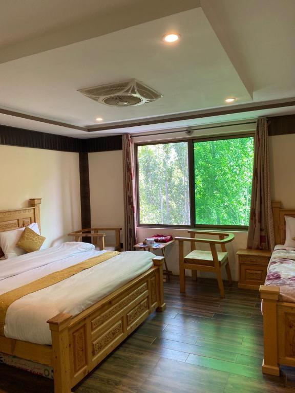 una camera con due letti e una grande finestra di Arcadian Resort Skardu a Skardu