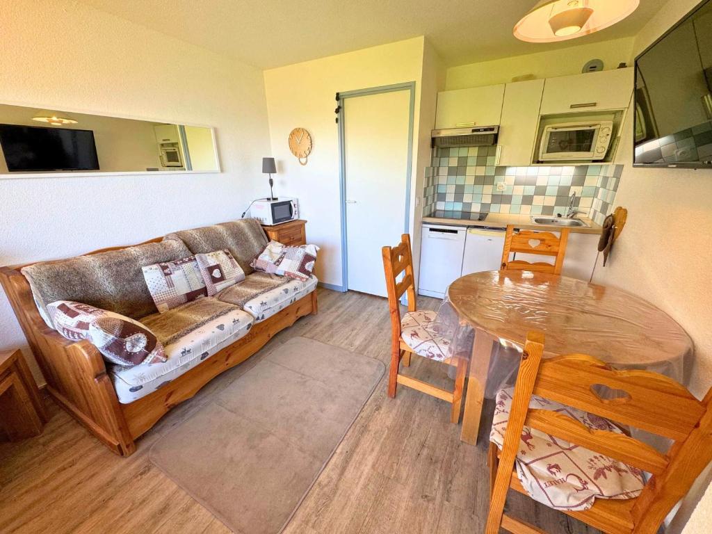 un salon avec un canapé et une table dans l'établissement Studio cabine cosy aux Menuires, 3 pers, pied des pistes, balcon, proche commodités - FR-1-452-291, aux Menuires