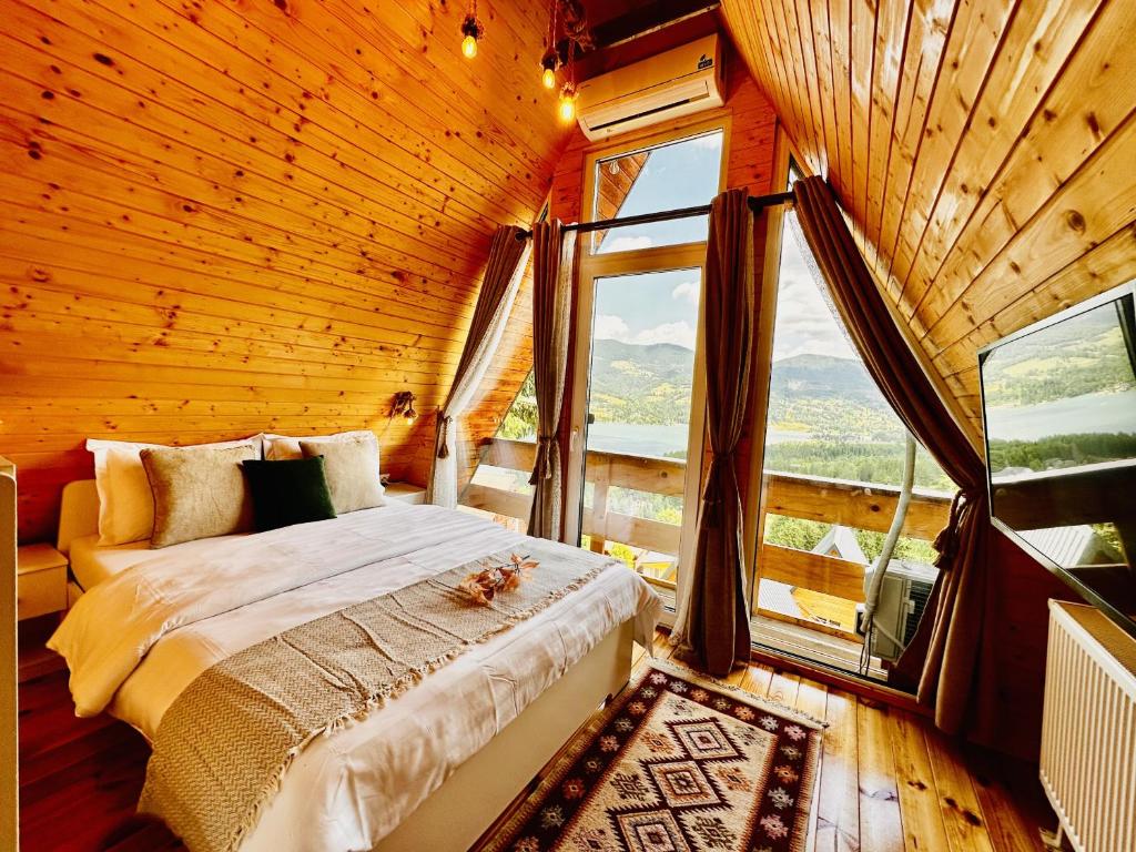 a bedroom with a bed in a room with a window at Lake Retreat Colibita in Colibiţa