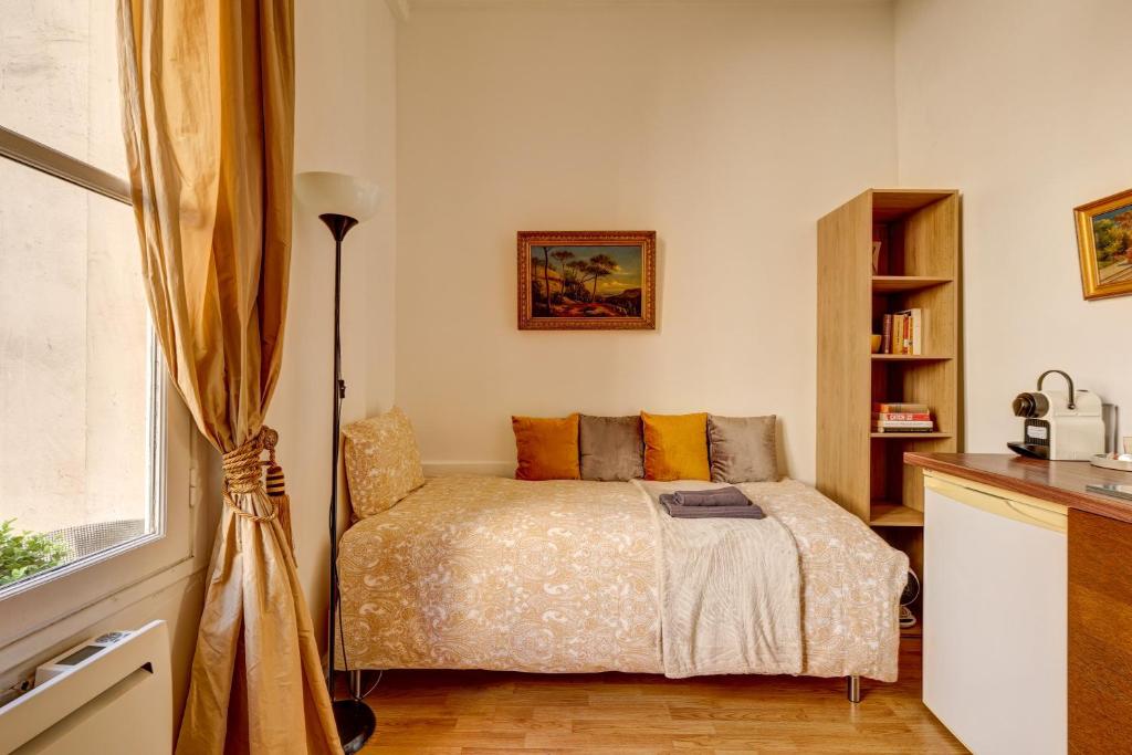 une chambre avec un lit et une fenêtre dans l'établissement Small Luxurious Room in the heart of Saint Germain, à Paris