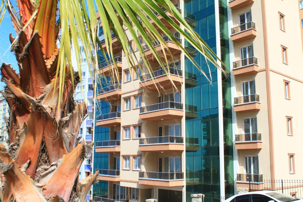a building with a palm tree in front of it at Qamar Prestige Suites in Trabzon