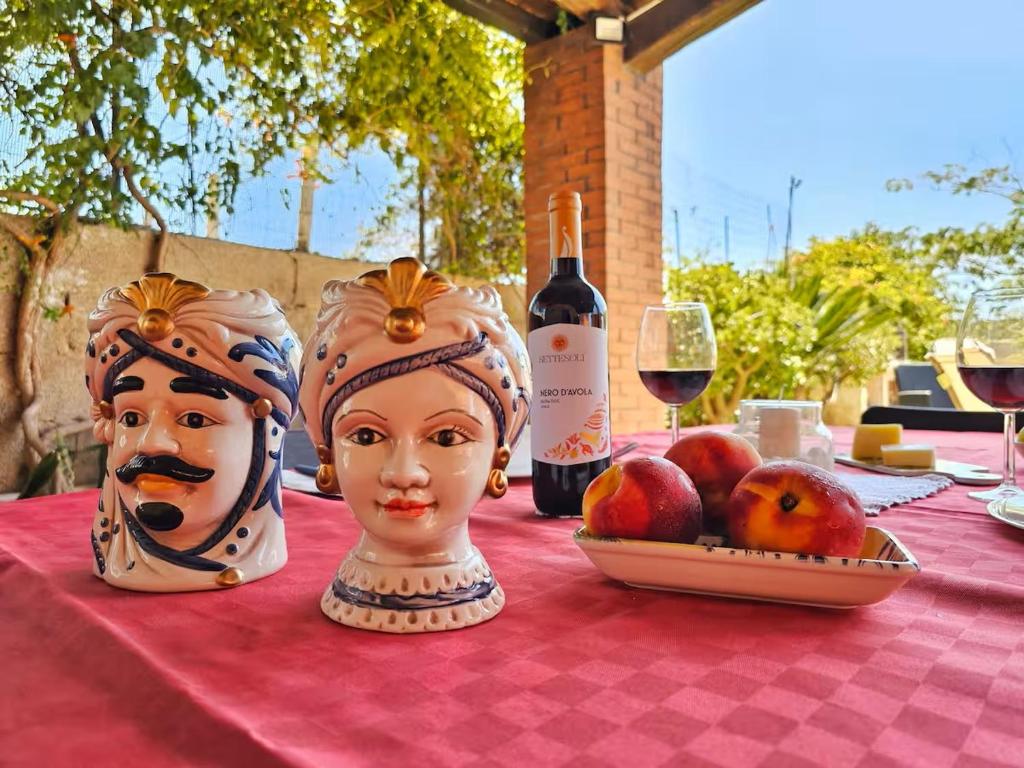 a table with two masks and a bottle of wine at Cirica Relax in Santa Maria Del Focallo