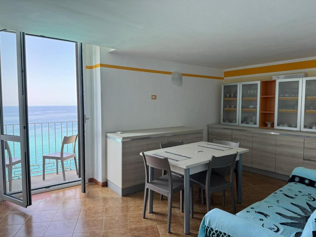 a kitchen with a table and chairs and a balcony at Harmonia Apartment with breathtaking view and a perfect location in Tropea