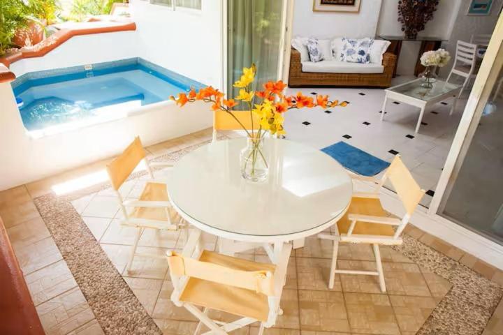 a table and chairs in a living room with a pool at Hermosa Villa en Ixtapa Zihuatanejo ideal para Parejas y Familia in Ixtapa