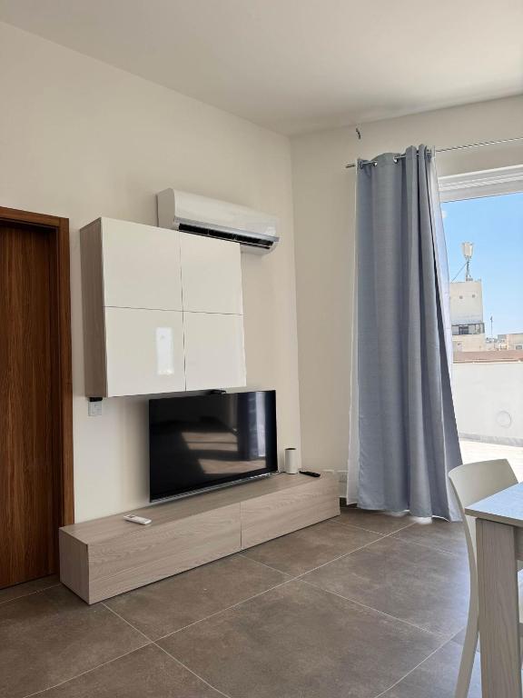 a living room with a tv and a fireplace at Cozy 1-Bedroom Penthouse - by HostMT in Taʼ Penza