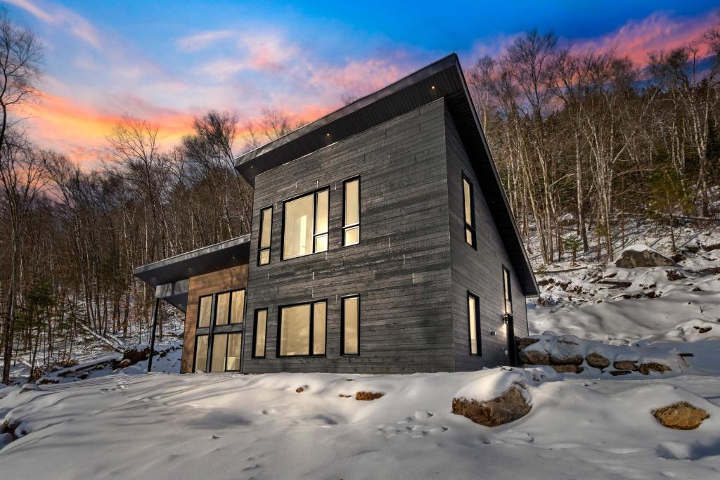 a house in the snow with a sunset at Havre du Mont in Saint Come