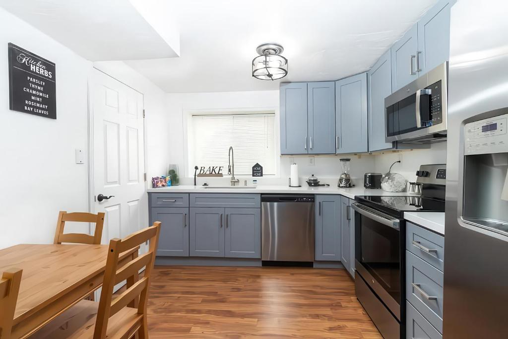 a kitchen with blue cabinets and a wooden table at Cozy Millcreek Home SLC in Millcreek