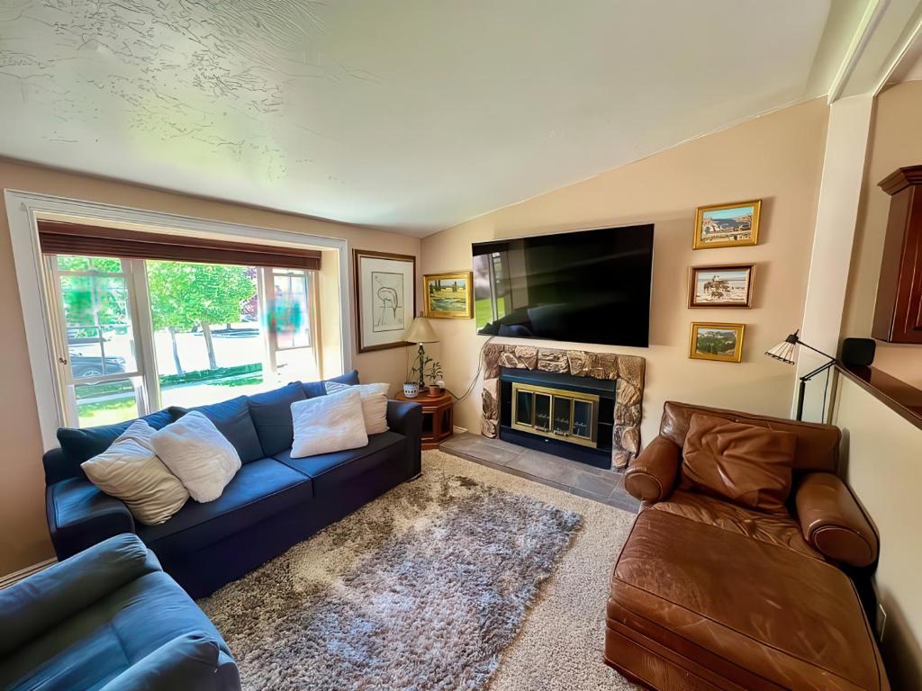 a living room with a blue couch and a fireplace at Charming Mountain Retreat with Enclosed Backyard and Artistic Flair in Millcreek