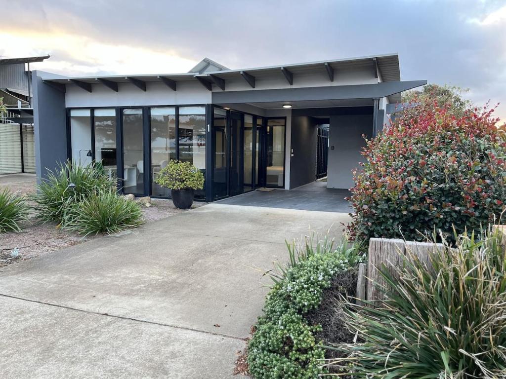 a modern house with glass doors and plants at Esperance Waterfront Apartment in Esperance