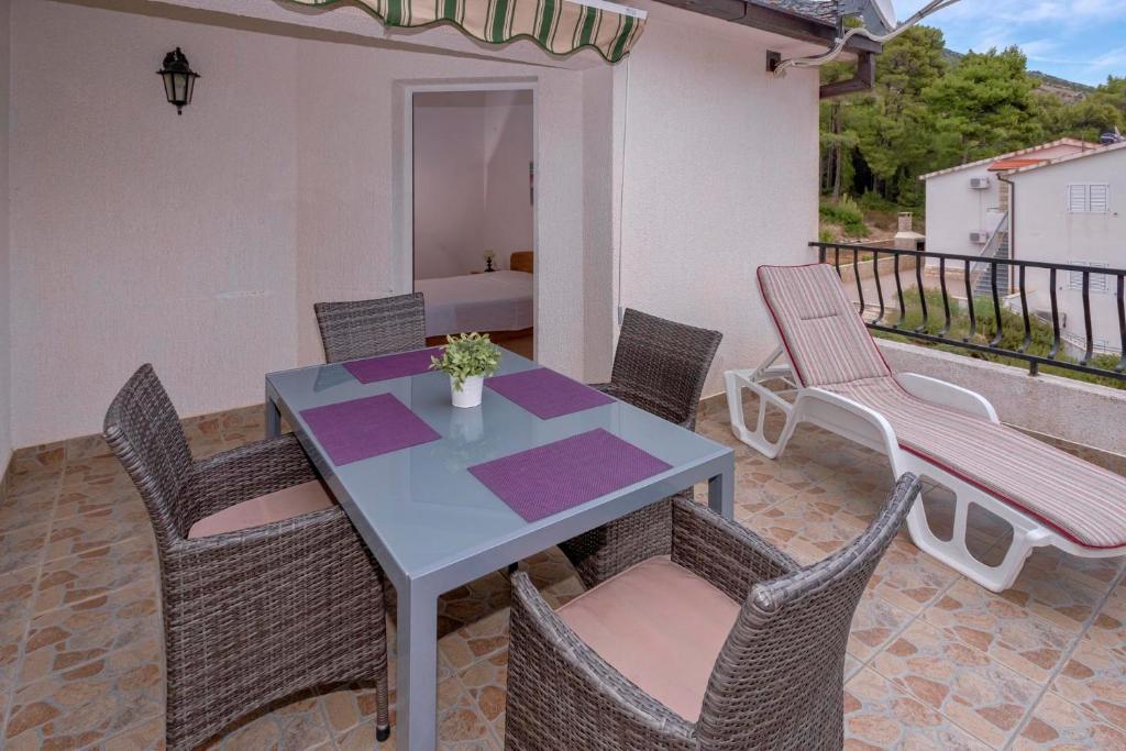 een patio met een tafel en stoelen en een bank bij Apartments Zora in Ivan Dolac