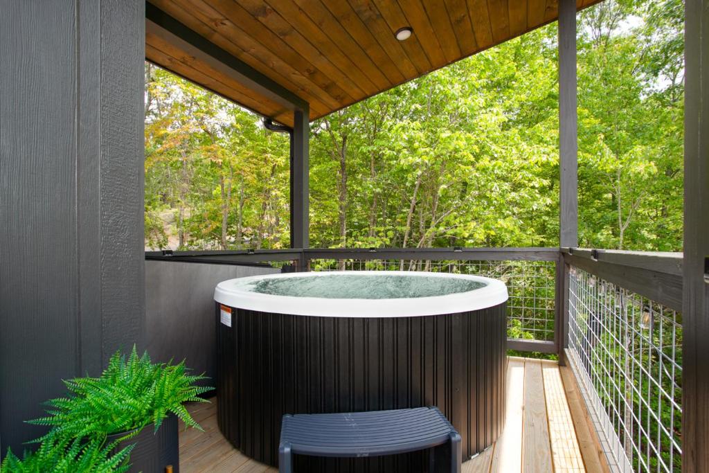 a hot tub on the deck of a house at The Little Timber Cozy Hot Tub Fireplace in Townsend