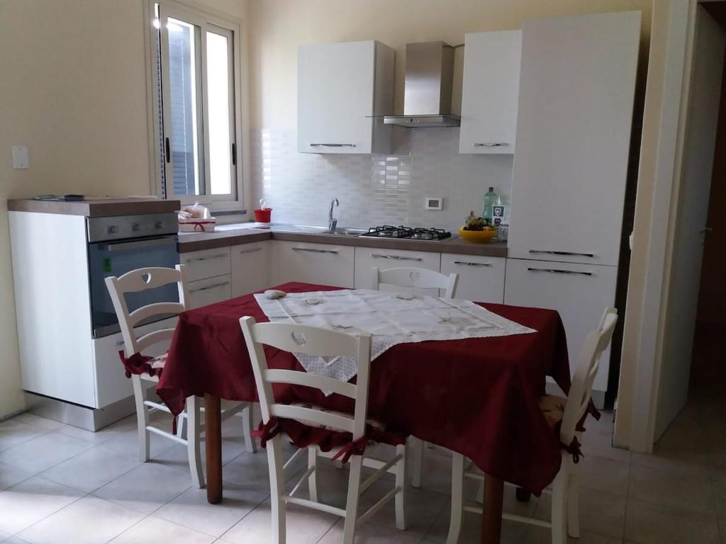 a kitchen with a table with a red table cloth on it at Da Alfio a Ragalna in Ragalna