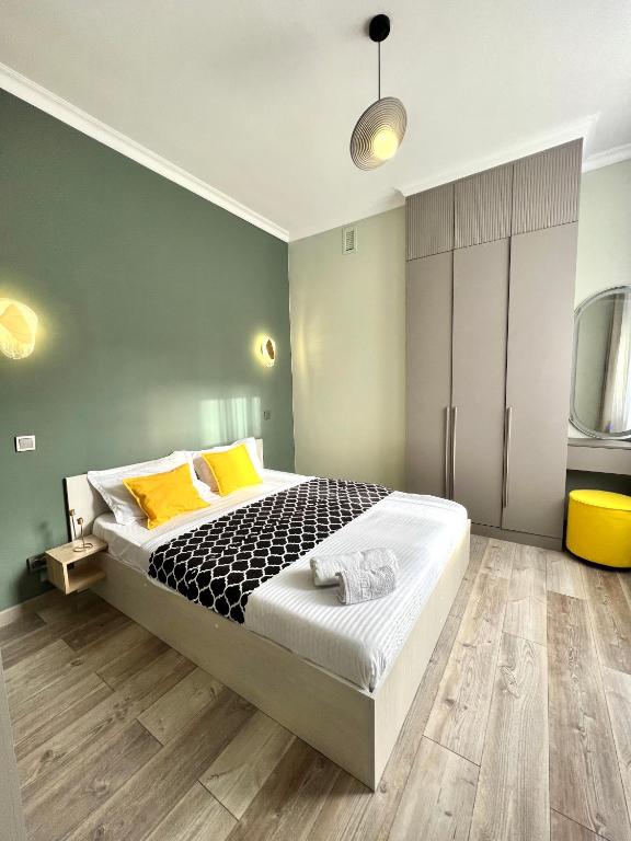 a bedroom with a bed with yellow pillows and a tv at С новым ремонтом Expo new life 2 in Taldykolʼ