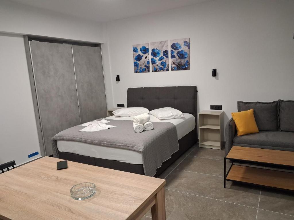 Un dormitorio con una cama, un sofá y una mesa. en Parga kamara studio, en Parga