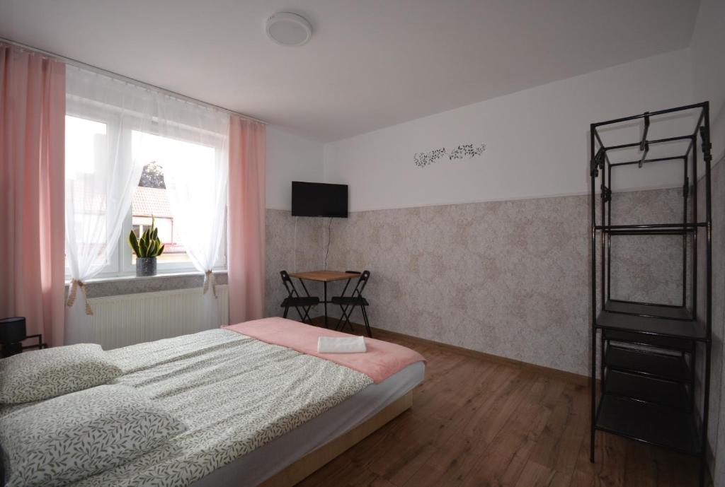 a bedroom with a bed and a window at Jaśmin -pokoje gościnne in Ustka