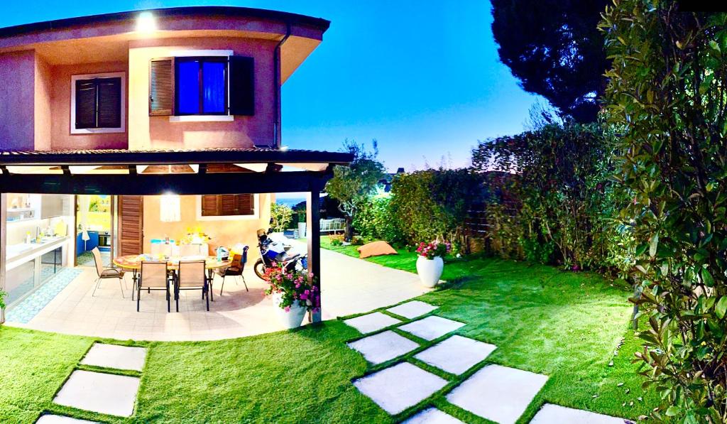 a garden with a house with a table and chairs at Luxury Villa Diamante in Casa del Lago