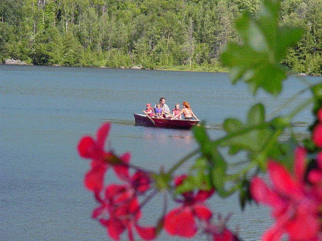 a group of people in a boat on a lake at Auberge du Lac Morency in Saint-Hippolyte