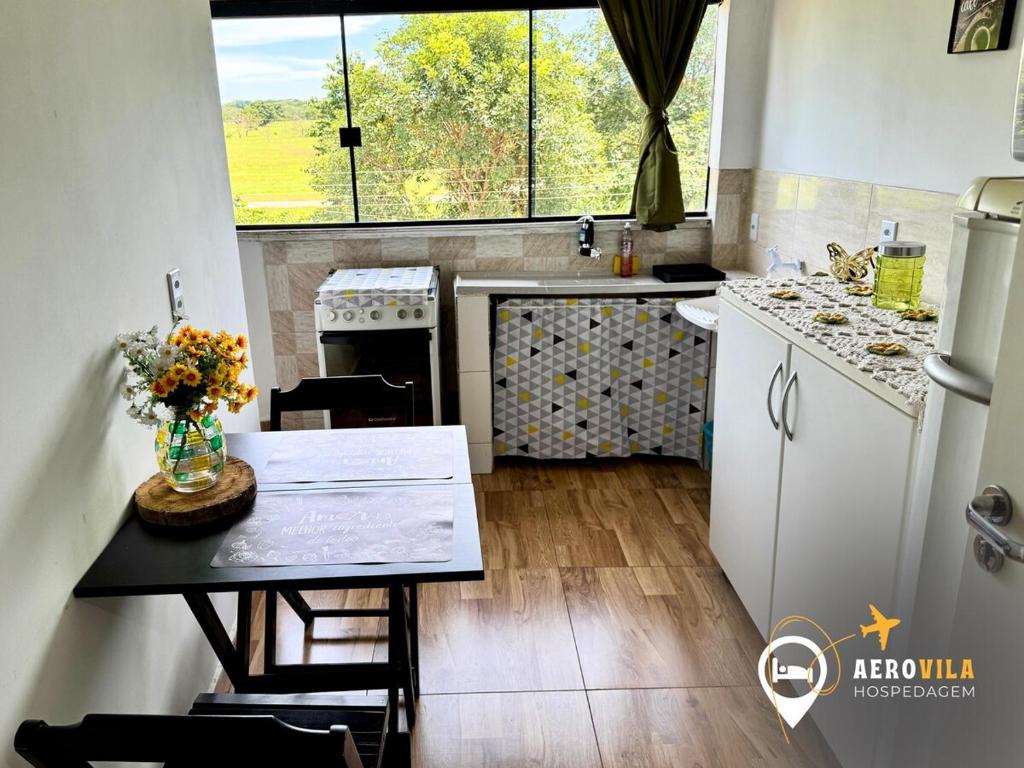 a small kitchen with a table and a window at Kitnet 16 Vila Telebrasília Asa Sul in Brasilia