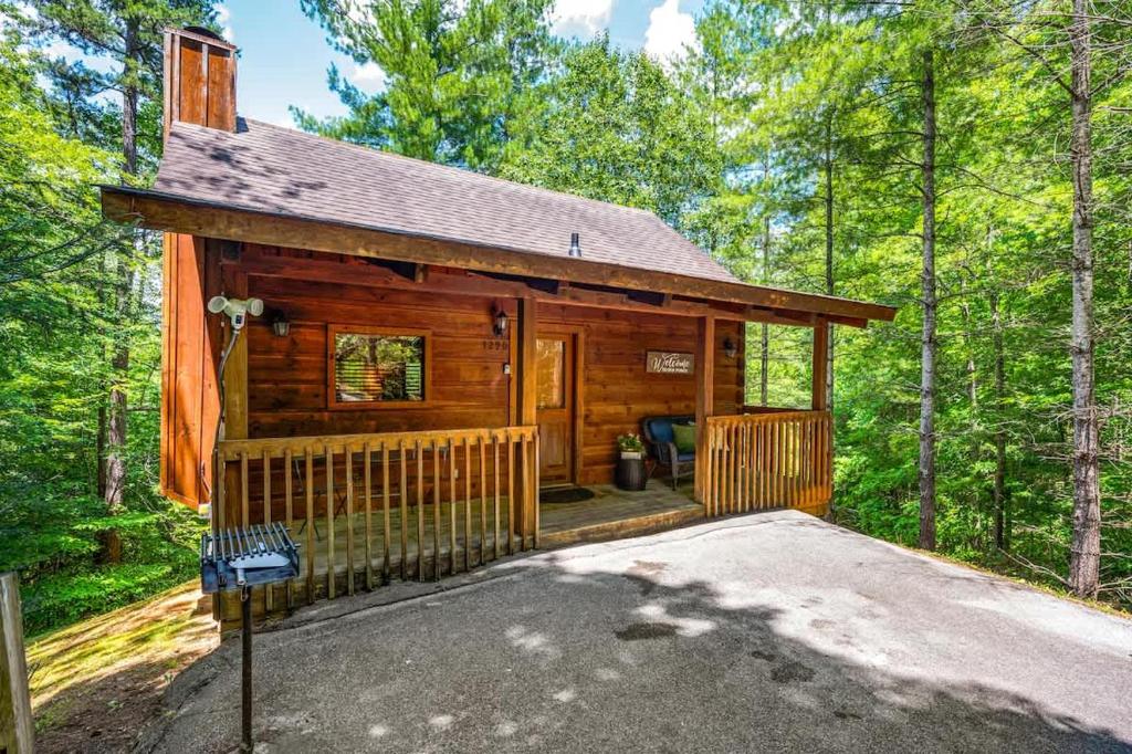 a log cabin in the woods with a driveway at Location Private Log Cabin Hot Tub Fireplace in Pigeon Forge