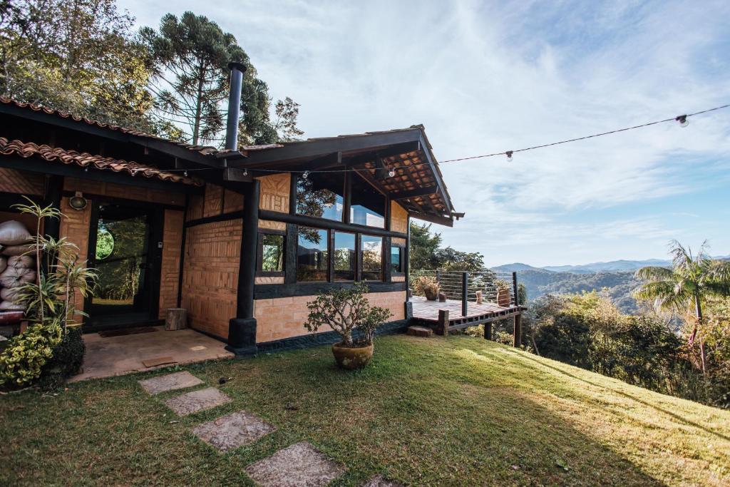 a house on a hill with a view of the mountains at Smart Hotel Reserva Santo Antônio do Pinhal in Santo Antônio do Pinhal
