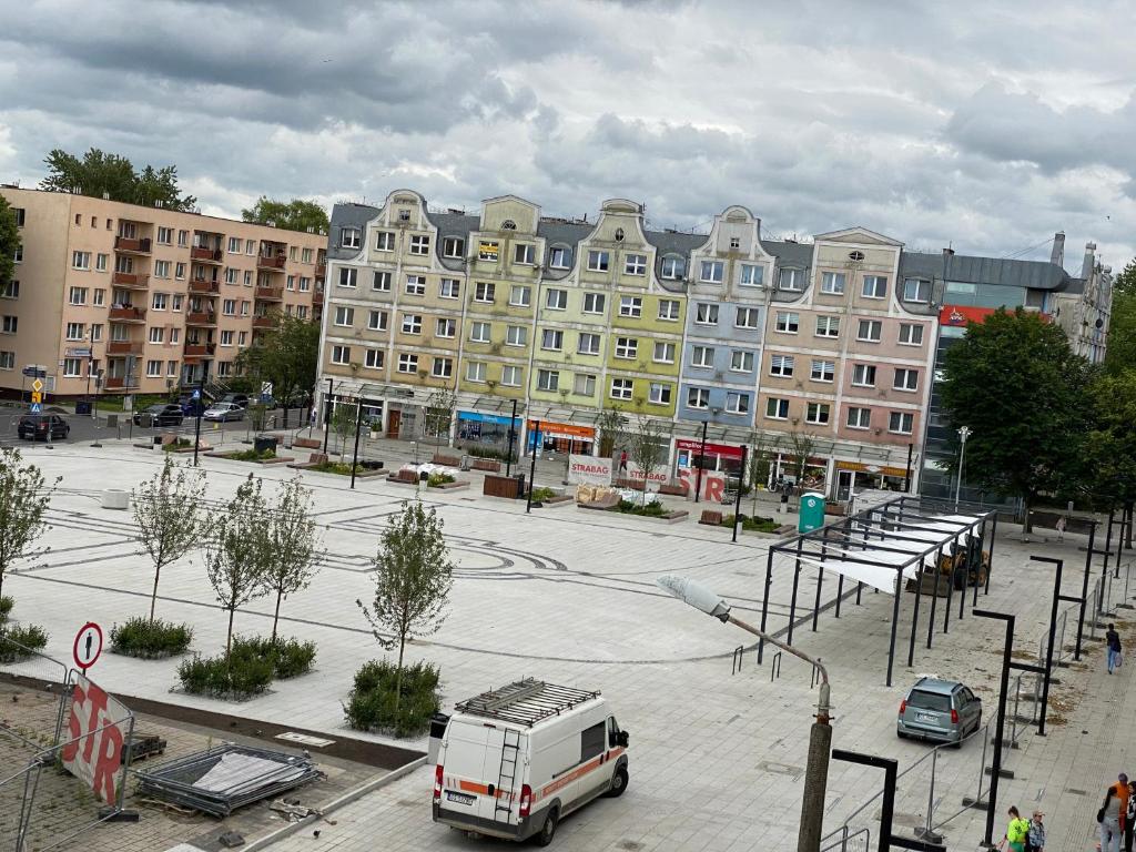 un furgone bianco parcheggiato di fronte a un grande edificio di STARY RYNEK Apartament Centrum a Słupsk