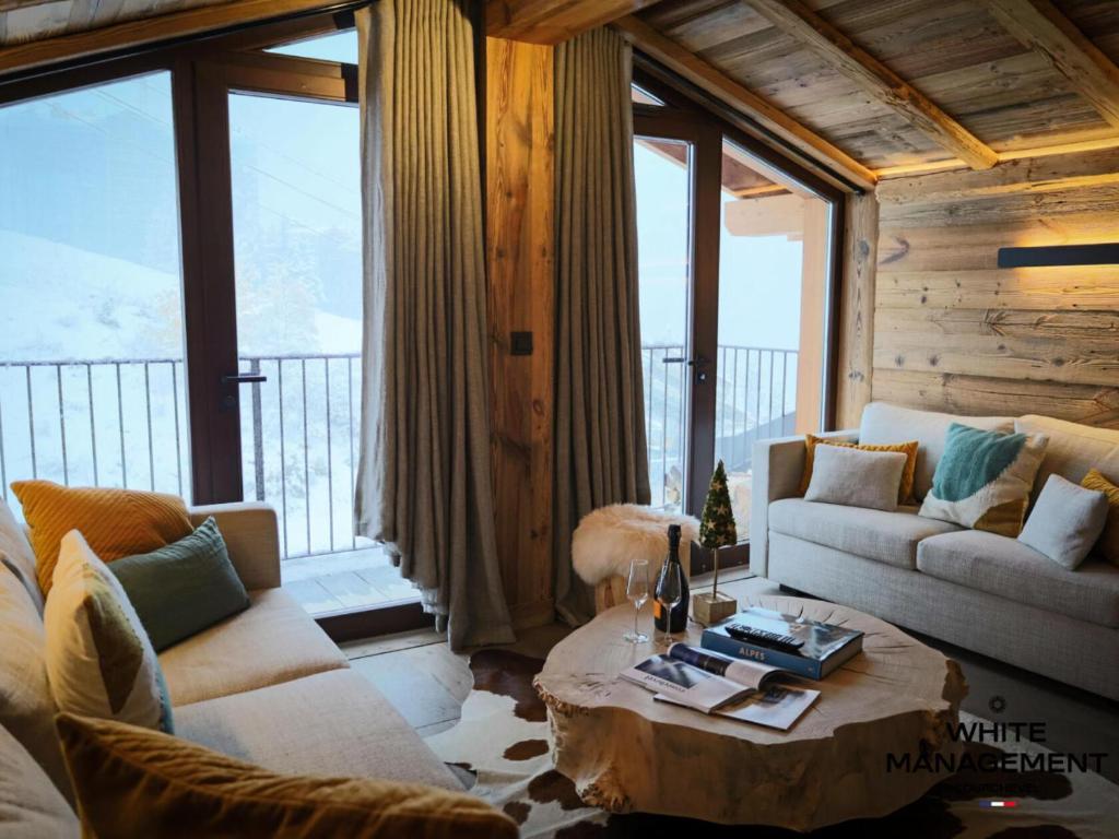 un salon avec un canapé et une table basse dans l'établissement Résidence Grandes Bosses - Beau penthouse au charme montagnard MAE-5844, à Courchevel